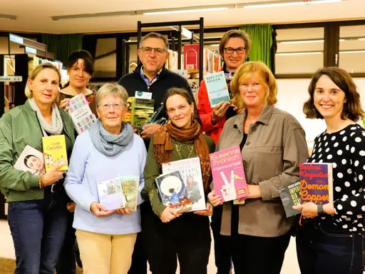 ein Mann und acht Frauen mit Büchern in den Händen 