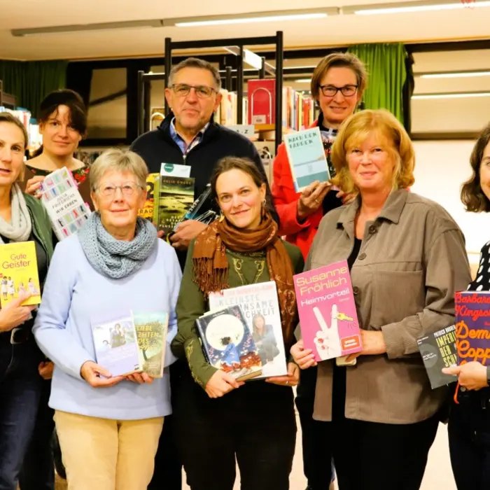 ein Mann und acht Frauen mit Büchern in den Händen 