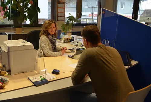 Mitarbeiterin und Bürger im Büro des Einwohnermelde- und Passamtes beim Termin
