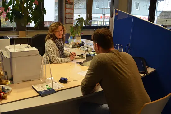 Mitarbeiterin und Bürger im Büro des Einwohnermelde- und Passamtes beim Termin