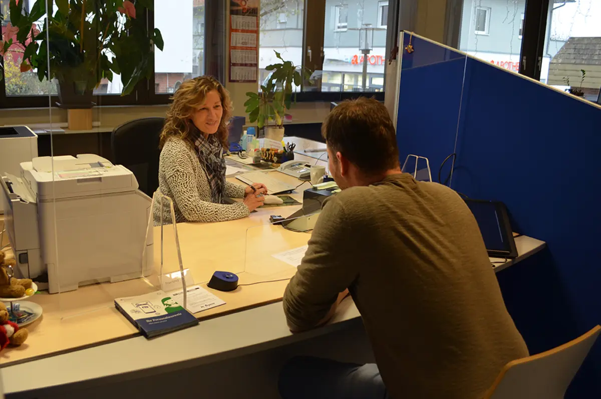 Mitarbeiterin und Bürger im Büro des Einwohnermelde- und Passamtes beim Termin