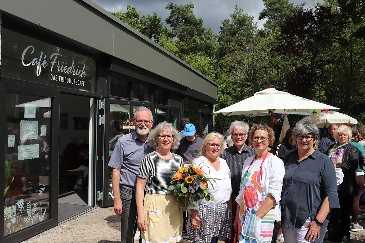 Vier Frauen und zwei Männer vor dem Café Friedrich. Im HIntergrund Gäste unter Sonnenschirmen.