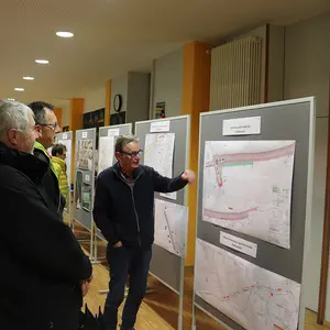 Drei Männer stehen vor einer Schautafel.