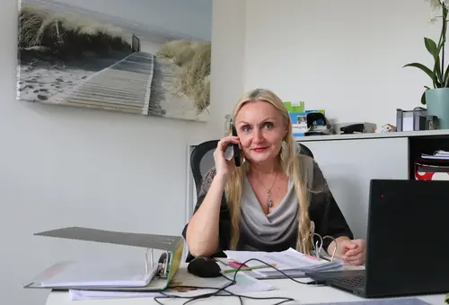 Nicoleta Schadi in ihrem Büro. Im Hintergrund ein Strandbild. 