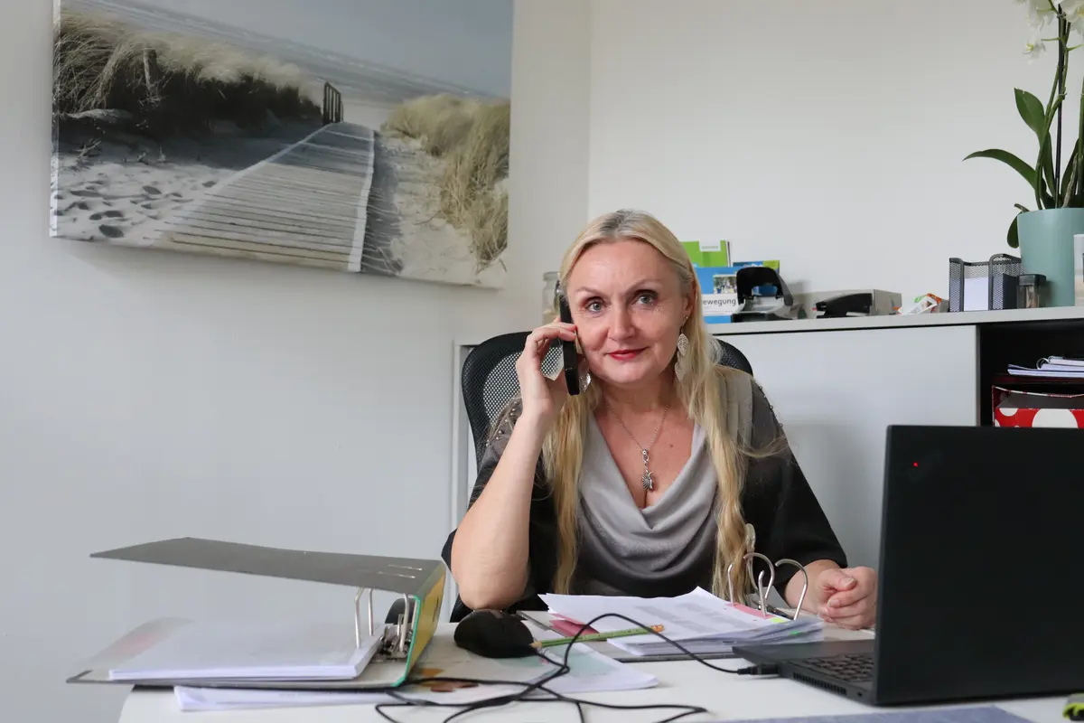 Nicoleta Schadi in ihrem Büro. Im Hintergrund ein Strandbild. 