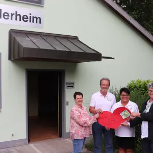 Drei Freuen und ein Mann vor dem Gebäude der Siedlervereinigung in Unterasbach