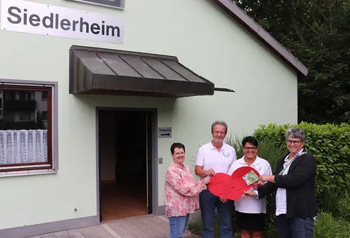Drei Freuen und ein Mann vor dem Gebäude der Siedlervereinigung in Unterasbach