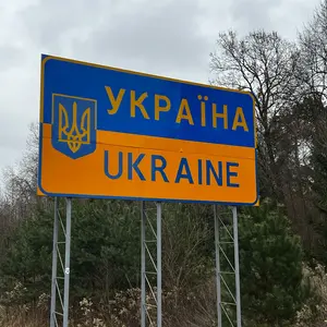 Schild in Gelb und Blau mit der Aufschrift Ukraine in lateinischen und kyrillischen Buchstaben