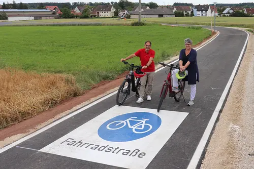 Verbindungsstraße mit dem großen blauen Fahrradpiktogramm, das auf der Straße augebracht ist.