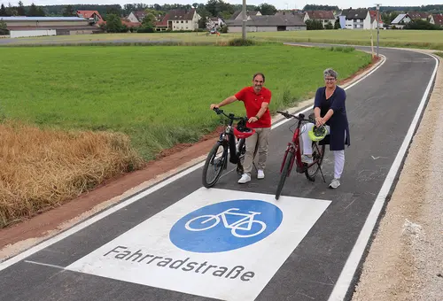 Verbindungsstraße mit dem großen blauen Fahrradpiktogramm, das auf der Straße augebracht ist.