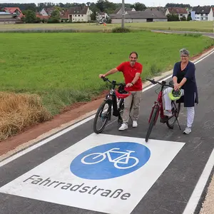 Verbindungsstraße mit dem großen blauen Fahrradpiktogramm, das auf der Straße augebracht ist.