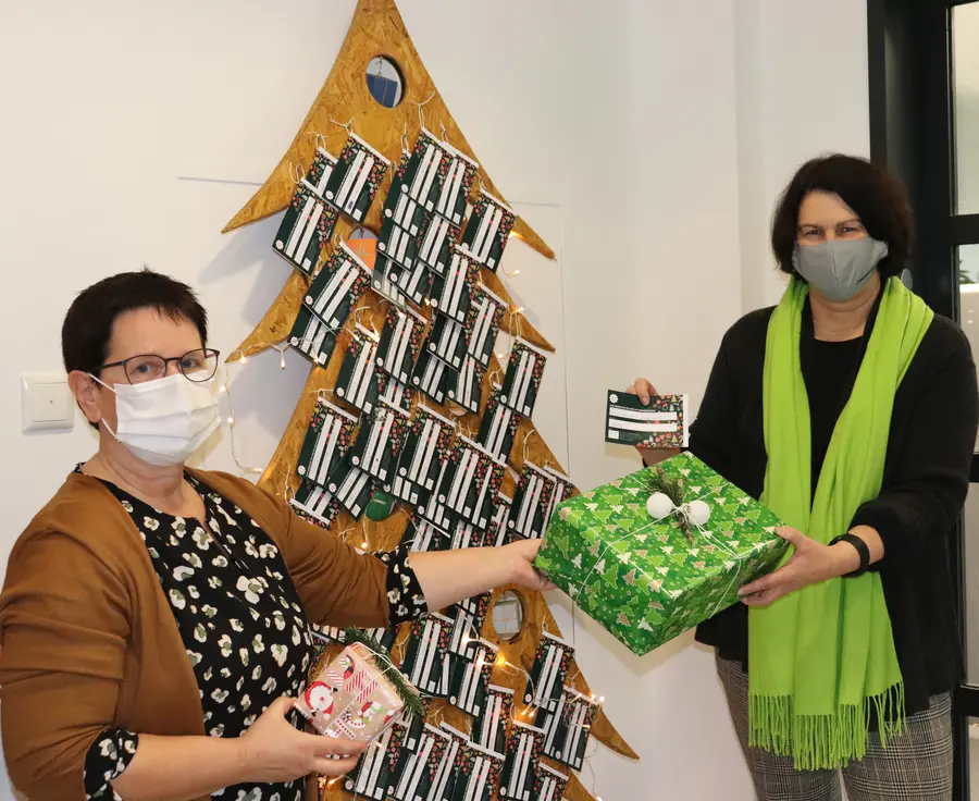 Birgit Huber und Renate Schwarz vor dem symbolischen Weihnachtsbaum aus Holz