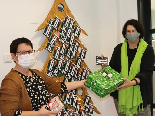 Birgit Huber und Renate Schwarz vor dem symbolischen Weihnachtsbaum aus Holz