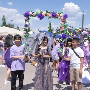 Zwei junge Männer halten einen Blumenbogen über eine junge Frau in traditionell philippinischer Kleidung.