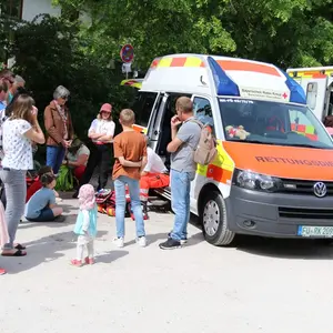 Junge und ältere Besucher des Tags der offenen Tür lassen sich die Ausrüstung der Sanitäter erklären.