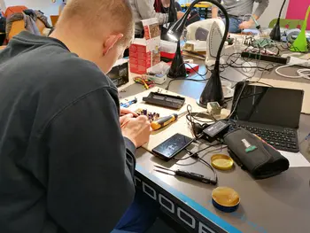 Ehrenamtliche Reparateure beim reparieren von Laptop, Wasserkocher usw.
