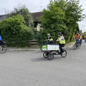 OLAF fährt dynamisch um die Ecke. Drumherum weitere Fahrerinnen. 