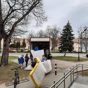 Helfer tragen Matratzen aus dem LKW.