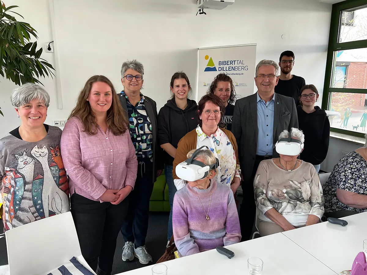 Sieben Frauen und zwei Männer beim Gruppen fot, Im Vordergrund zwei Frauen mit VR-Brille