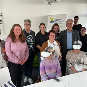 Sieben Frauen und zwei Männer beim Gruppen fot, Im Vordergrund zwei Frauen mit VR-Brille