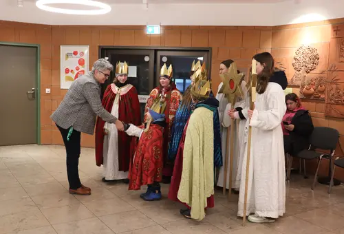 Bürgermeisterin schüttelt die Hand des jüngsten Sternsingers. 