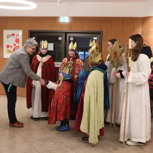 Bürgermeisterin schüttelt die Hand des jüngsten Sternsingers. 