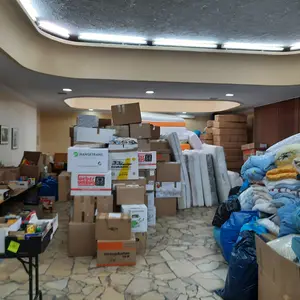 Große Stapel mit Decken, Kartons, Matratzen und weiteren Hilfsgütern 