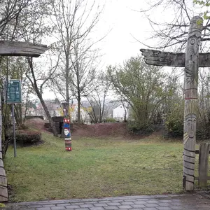 Grundstückseingang mit zwei Säulen, die an Totempfähle erinnern 