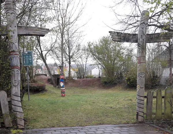 Grundstückseingang mit zwei Säulen, die an Totempfähle erinnern 