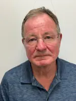 älterer Mann mit Brille und blaugrauem Poloshirt