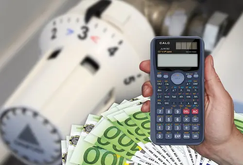 Ein Heizungsventil, Geldscheine und ein Taschenrechner symbolisieren die Möglichkeit, Energie und Geld zu sparen. 