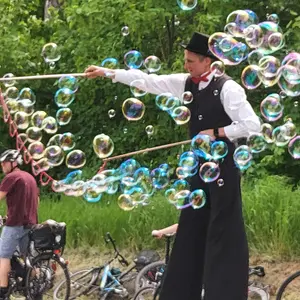 Stelzenmann macht Riesenseifenblasen. 