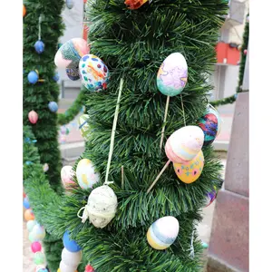 Ostereier, die mit Holzstäben am Osterbrunnen festgemacht sind. 