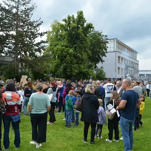 Zahlreiche Menschen auf der Schulwiese.