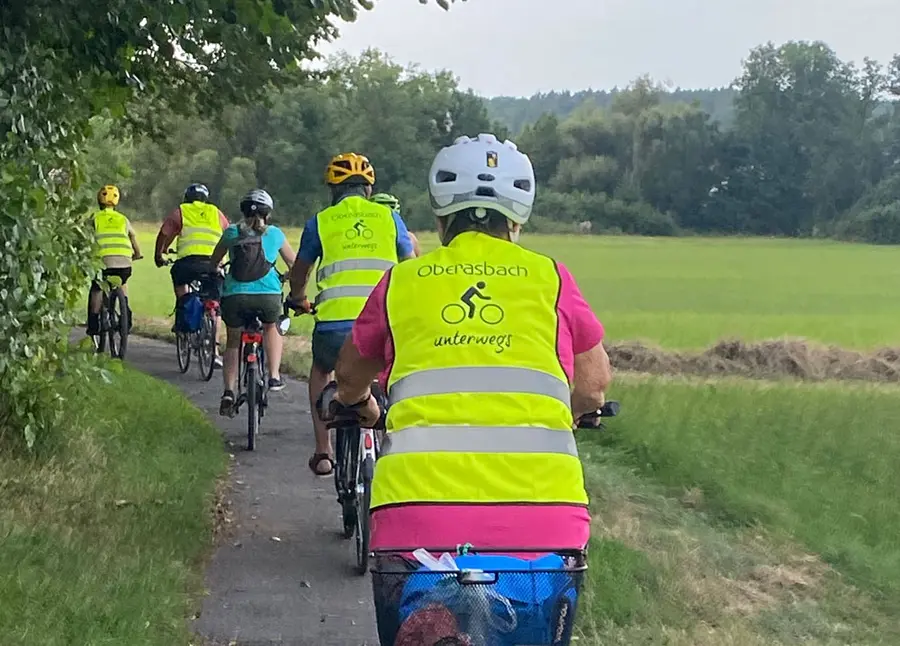 Eine Gruppe von Rafahrern mit gelben Warnwesten mit der Aufschrift "Oberasbach unterwegs"