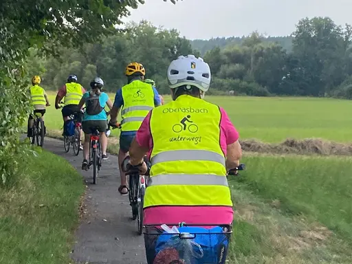 Eine Gruppe von Rafahrern mit gelben Warnwesten mit der Aufschrift "Oberasbach unterwegs"
