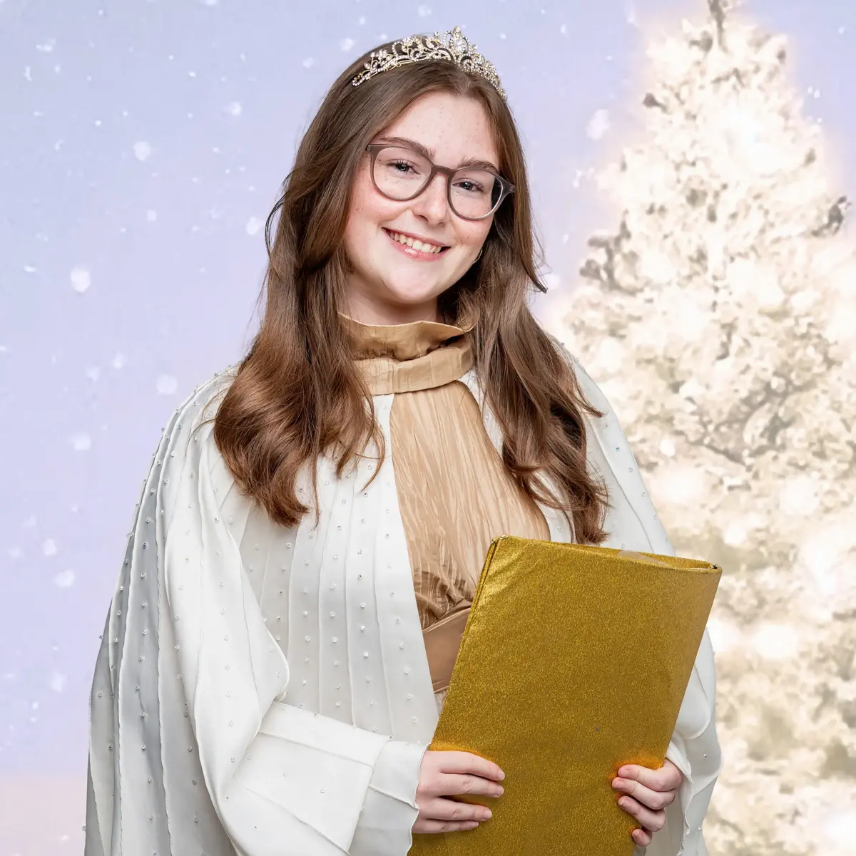 Das Oberasbacher Christkind mit einem goldenen Buch in der Hand vor einem hell leuchtenden Weihnachtsbaum.