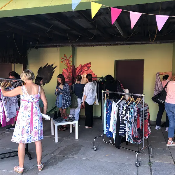 Frauen stöbern auf den Tischen nach Kleidungsstücken