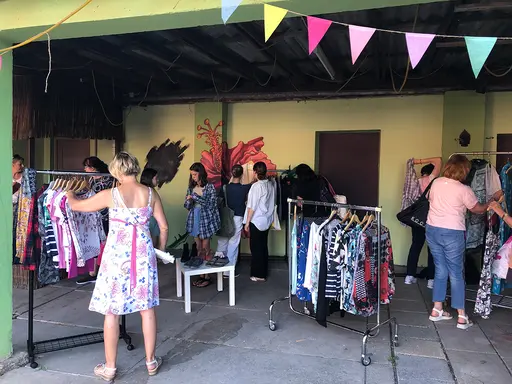 Frauen stöbern auf den Tischen nach Kleidungsstücken