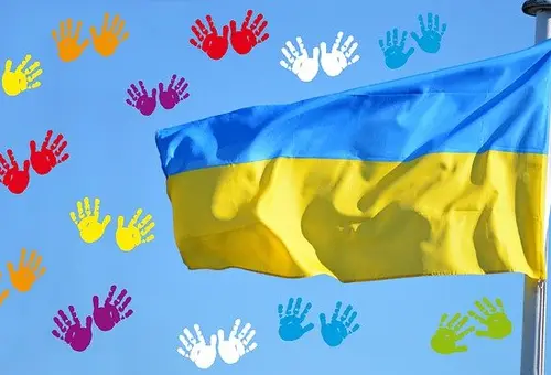 Bildkollage aus einer Ukrainischen Flaggen und zahlreichen bunten Kinderhandabdrücken
