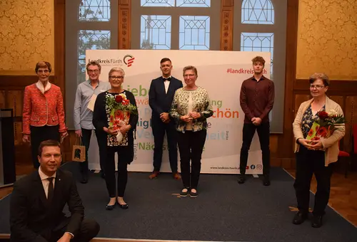 Sieben geehrte Bürgerinnen und Bürger mit Landrat Matthias Dießl