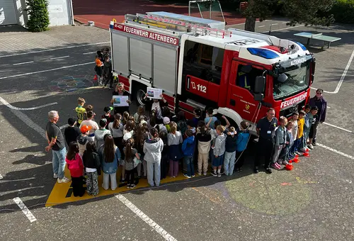 Ein Feuerwehrauto mit 40-50 Kindern, die im toten Winkel stehen.