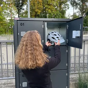 Ein Frau legt inen Fahrradhelm in das Schließfach.