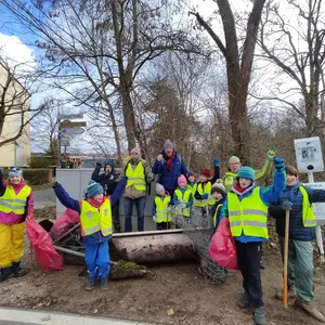 Gruppe von Erwachsenen und Kindern mit Badewanne, Waschbecken und Maschendraht