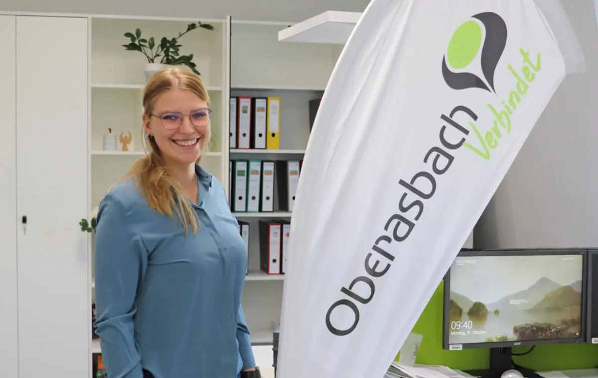 Michaela Heckel neben einer Beachflag mit dem Logo Oberasbach verbindet. 