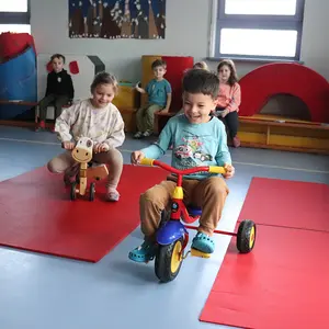 Zwei Kinder mit Dreirad und Roller auf zwei unterschiedlich dicken Belägen.
