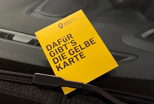 Gelbe Karte mit einer Verwarnung an der Windschutzscheibe eine Kfz