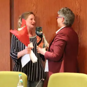 Koch mit Blumenstrauß und Huber im Sitzungssaal