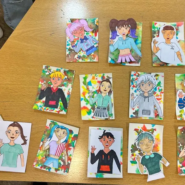 Auf einem Tisch legen nebeneinander 13 Zeichnungen im Mangastil. 