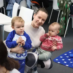 Mutter mit zwei Kindern auf dem Arm 